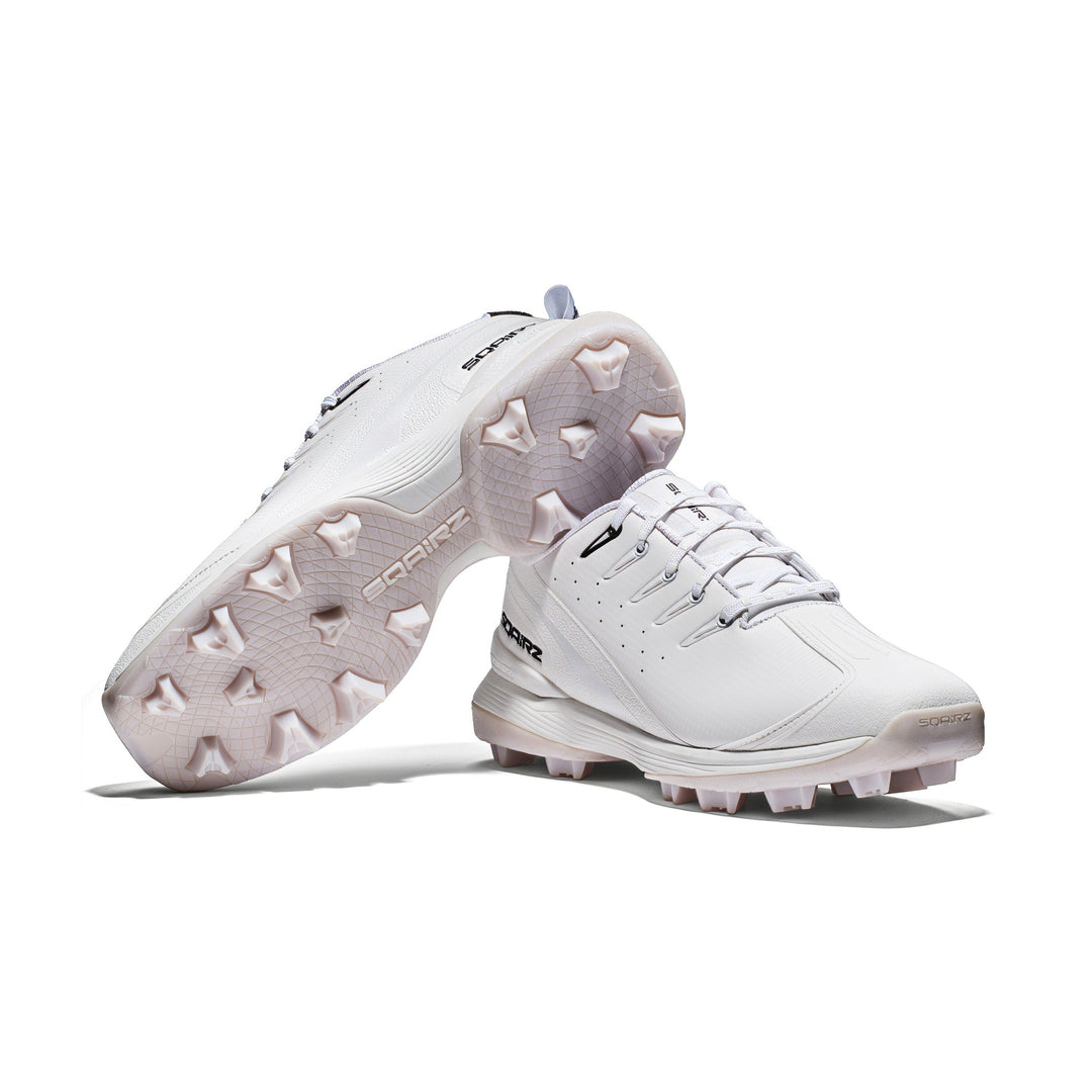 White SQAIRZ youth molded cleats displayed as a pair on the field, built for young baseball and softball players seeking stability, balance, and confidence.